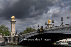 The Pont Alexandre III and its famous flames against dark clouds