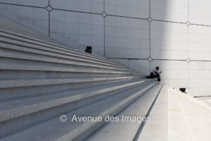 On the phone on the steps of the Grande Arche in Paris La Défense